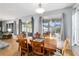 Dining area with a wooden table set for six, overlooking a screened-in patio at 13187 Se 93Rd Terrace Rd, Summerfield, FL 34491