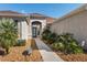 Charming single-story home showcasing a inviting entrance with lush landscaping, decorative rocks, and a well-maintained walkway at 13187 Se 93Rd Terrace Rd, Summerfield, FL 34491