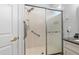 Bathroom shower featuring hand rails, a shower seat, sliding glass doors and silver hardware at 13187 Se 93Rd Terrace Rd, Summerfield, FL 34491