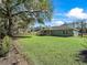 Green backyard featuring a well-maintained lawn and partial view of the light green house at 14605 Sw 20Th Pl, Ocala, FL 34481