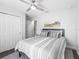 Bedroom with large window, ceiling fan, and grey-and-white striped bedspread at 14605 Sw 20Th Pl, Ocala, FL 34481