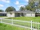 Single-story home with well-maintained lawn and a white picket fence lining the front yard at 14605 Sw 20Th Pl, Ocala, FL 34481