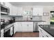 Modern kitchen featuring white cabinets, stainless steel appliances, granite countertops, and tile backsplash at 14605 Sw 20Th Pl, Ocala, FL 34481