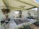 Covered patio with wicker furniture, plants, and a ceiling fan overlooks a lush backyard at 14605 Sw 20Th Pl, Ocala, FL 34481