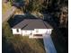 An aerial view of a newly constructed one-story home with a dark roof and a lengthy driveway at 15123 Se 63Rd Ct, Summerfield, FL 34491