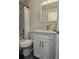 Bathroom featuring vanity with framed mirror, white cabinets and a shower with white tile at 15123 Se 63Rd Ct, Summerfield, FL 34491