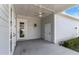 Covered back porch with ceiling fan, concrete floor, and an exterior door at 2032 Se 27Th Rd, Ocala, FL 34471