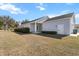 Exterior rear elevation featuring covered porch, exterior door, and grass at 2032 Se 27Th Rd, Ocala, FL 34471