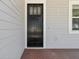 Close-up of a dark, craftsman-style front door with glass panels and brick porch flooring at 2032 Se 27Th Rd, Ocala, FL 34471