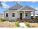 Charming single-story home featuring a welcoming front porch with red brick pillars and a well-manicured lawn at 2032 Se 27Th Rd, Ocala, FL 34471