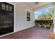 Inviting front porch with brick flooring, contrasting gray siding, and a black front door at 2032 Se 27Th Rd, Ocala, FL 34471