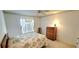 Cozy bedroom featuring a ceiling fan, floral accents, and a wooden dresser, creating a warm and inviting space at 21353 Sw Beach Blvd, Dunnellon, FL 34431