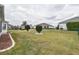 Backyard with green lawn, decorative trimmed trees, and a green chain link fence at 2209 Nw 55Th Avenue Rd, Ocala, FL 34482