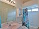 Bright bathroom with a tub shower, leaf-patterned shower curtain, and a pink vanity at 2209 Nw 55Th Avenue Rd, Ocala, FL 34482