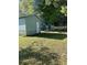 Storage sheds sit on a lot that is surrounded by green grass and trees at 2851 Ne 162Nd Ln, Citra, FL 32113