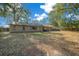 Backyard view featuring a large, well-maintained lawn and mature shade trees at 2923 Se 14Th St, Ocala, FL 34471