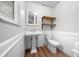 Charming bathroom features pedestal sink, wainscoting and modern shelves at 2923 Se 14Th St, Ocala, FL 34471