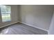 Bright bedroom with a window and wood-look laminate floors at 3373 Se 148Th Pl, Summerfield, FL 34491