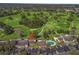 Aerial view of condo buildings, parking, and swimming pool backing to the golf course at 3437 E Fort King St # 220, Ocala, FL 34470