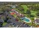 Aerial view of condo buildings, parking, and swimming pool backing to the golf course at 3437 E Fort King St # 220, Ocala, FL 34470