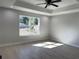 Serene bedroom with a large window, tray ceiling, and neutral walls creating a calming atmosphere at 3684 Se 130Th Pl, Belleview, FL 34420