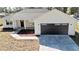 New home exterior showcases a dark garage door, fresh landscaping, and modern design at 3684 Se 130Th Pl, Belleview, FL 34420