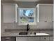 Well-lit kitchen featuring granite countertops, a stainless steel sink, and bright cabinets at 3684 Se 130Th Pl, Belleview, FL 34420