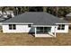 Aerial view of the home's rear, showcasing the covered porch, modern design, and backyard at 3684 Se 130Th Pl, Belleview, FL 34420