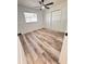 Bright bedroom showcasing wood-look flooring, a ceiling fan, and a spacious closet at 4480 Ne 25Th Ave, Ocala, FL 34479