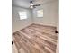 Cozy bedroom featuring wood-look flooring, a ceiling fan, and windows for natural light at 4480 Ne 25Th Ave, Ocala, FL 34479