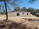 View of the back of the house showing the sliding glass door and outdoor patio at 46 Malauka Dr, Ocklawaha, FL 32179