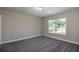 This bedroom features neutral paint, plush gray carpet, and a window offering natural light at 46 Malauka Dr, Ocklawaha, FL 32179