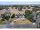 Expansive aerial view of a white home with manicured lawns, surrounded by trees and an open field at 4620 Nw 84Th Ter, Ocala, FL 34482