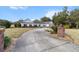 Long driveway leading to a well-maintained home with a beautifully landscaped front yard and garden at 4620 Nw 84Th Ter, Ocala, FL 34482