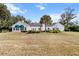 The exterior of this well-manicured, white home features a lush green lawn at 4620 Nw 84Th Ter, Ocala, FL 34482