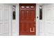 Elegant red front door with sidelights and decorative hardware, creating a welcoming entrance to the home at 4620 Nw 84Th Ter, Ocala, FL 34482