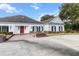 Charming home featuring a red door, black shutters, brick accents, and lush landscaping at 4620 Nw 84Th Ter, Ocala, FL 34482