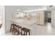 Well-lit kitchen featuring white cabinetry and a breakfast bar with wooden stools at 4620 Nw 84Th Ter, Ocala, FL 34482