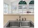 Close-up of a kitchen sink with a view of the outdoors through white-framed windows at 4620 Nw 84Th Ter, Ocala, FL 34482