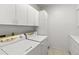 A bright laundry room with white cabinets, countertops, and modern washer and dryer at 4620 Nw 84Th Ter, Ocala, FL 34482