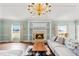 Bright living room featuring a grand fireplace, wood floors, area rug, chandelier and comfortable sectional sofa at 4620 Nw 84Th Ter, Ocala, FL 34482