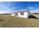 Exterior view of the backyard featuring a covered patio and a large grassy area at 5589 Sw 78Th Ave Rd, Ocala, FL 34474