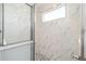 Shower with rainfall shower head, mosaic tile floor, marble wall tile, and a window at 5589 Sw 78Th Ave Rd, Ocala, FL 34474