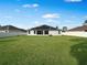 Expansive backyard features a lush green lawn, white fence, and newly installed solar panels at 5898 Sw 116Th Street Rd, Ocala, FL 34476