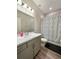 Well-lit bathroom with a modern vanity, white countertops, and a shower-tub combo with a stylish geometric curtain at 5898 Sw 116Th Street Rd, Ocala, FL 34476