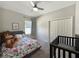 Comfortable bedroom with a bed, crib, neutral colors, and closet offering a calming retreat at 5898 Sw 116Th Street Rd, Ocala, FL 34476