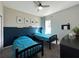 Stylish bedroom featuring a navy accent wall, ceiling fan, and window with natural light at 5898 Sw 116Th Street Rd, Ocala, FL 34476