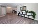 Spacious living area showcasing modern wood flooring, a decorative console table, and seamless flow to other living areas at 5898 Sw 116Th Street Rd, Ocala, FL 34476