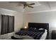 Spacious main bedroom with tray ceiling, ceiling fan, a bedside table, and large bed at 61 Pecan Drive Loop, Ocala, FL 34472