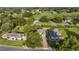 Aerial view of an expertly landscaped home that backs up to a golf course surrounded by trees at 6174 Spinnaker Loop, Lady Lake, FL 32159